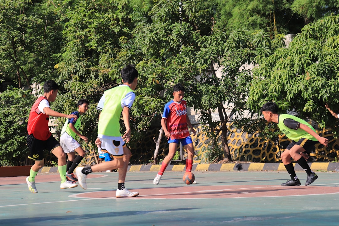 youth soccer drills for beginners - Boys playing soccer on a sunny outdoor court.