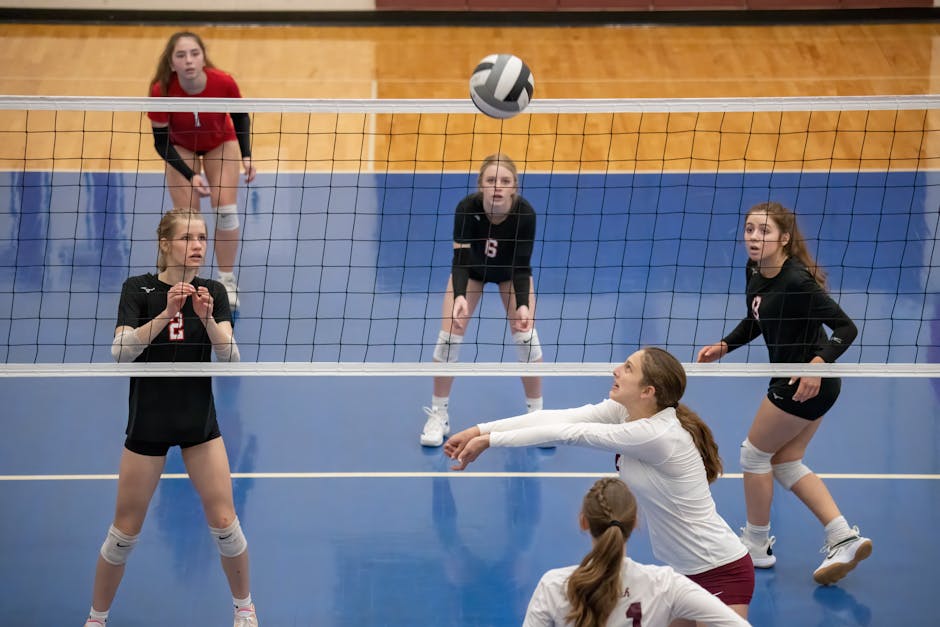 youth volleyball skills - Female athletes engage in a competitive volleyball game indoors in Rochester, MN.