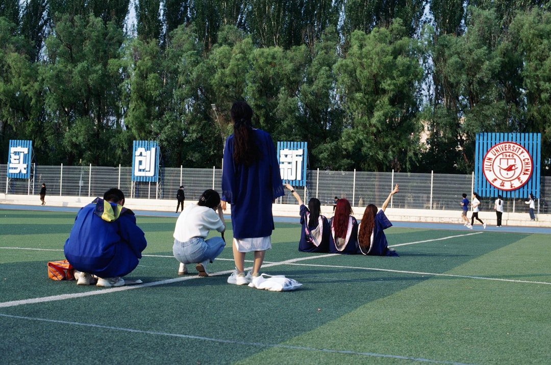prevent youth sports injuries - A group of people sitting on top of a tennis court