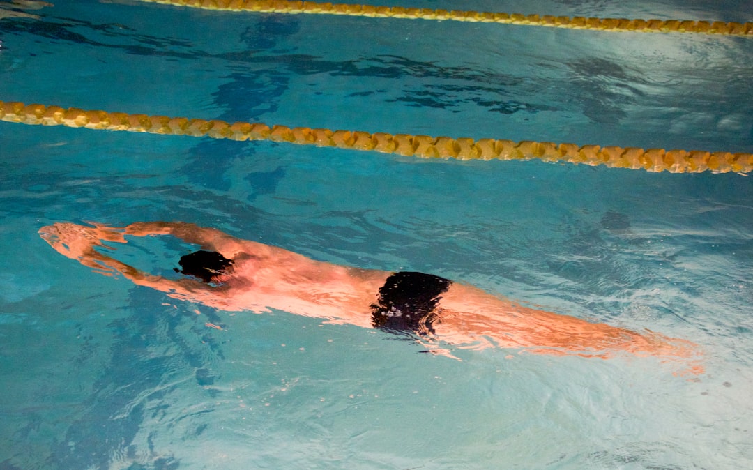 swimming technique for beginners - man swimming on pool