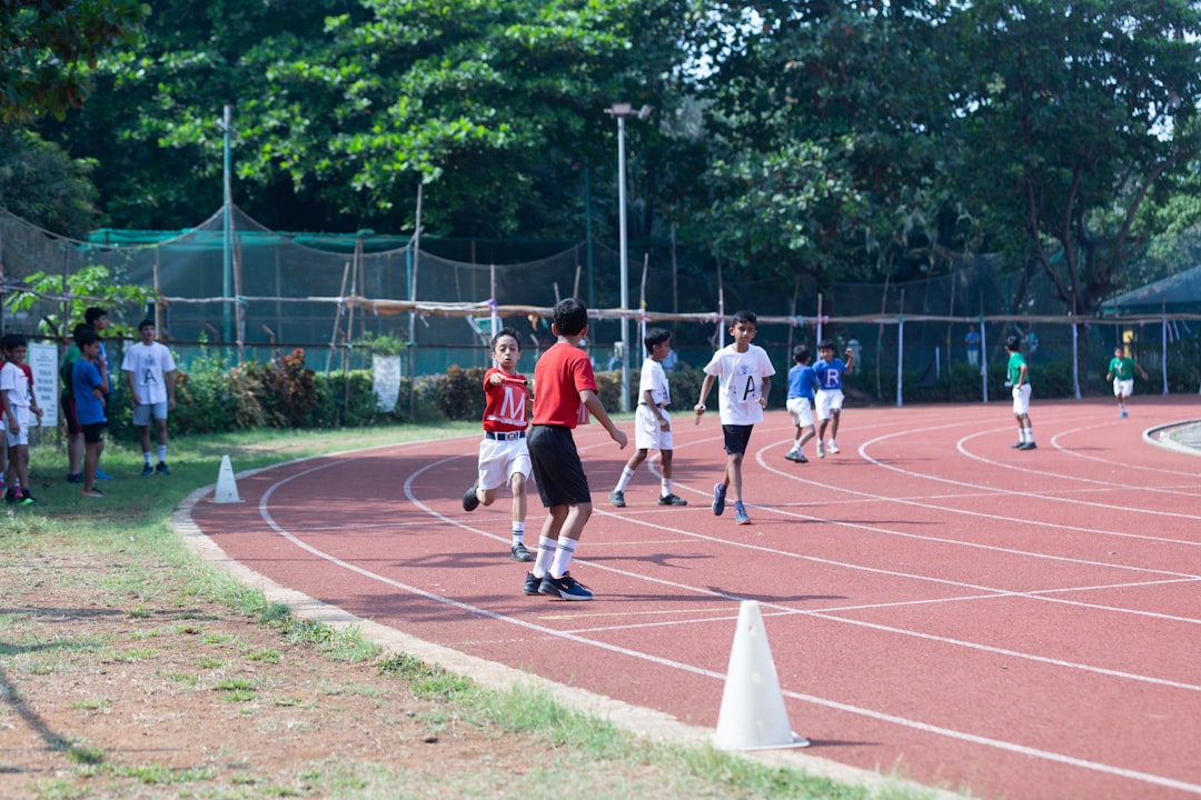 youth football conditioning drills - a group of young men standing on top of a track