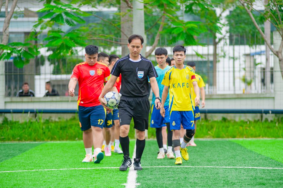 youth sports - Soccer players and referee entering a field in Hanoi, Vietnam, showcasing teamwork and sportsmanship.